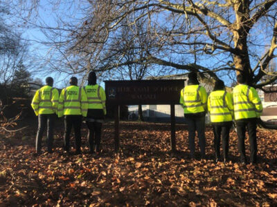 six police offers stand on either side of our blue coat academy sign