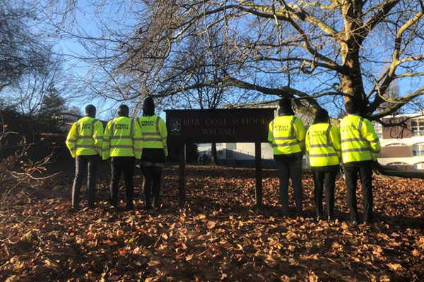 six police offers stand on either side of our blue coat academy sign