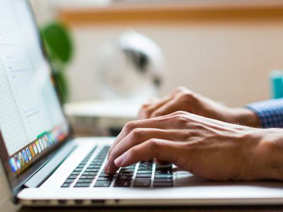 decorative image of someone typing on a laptop