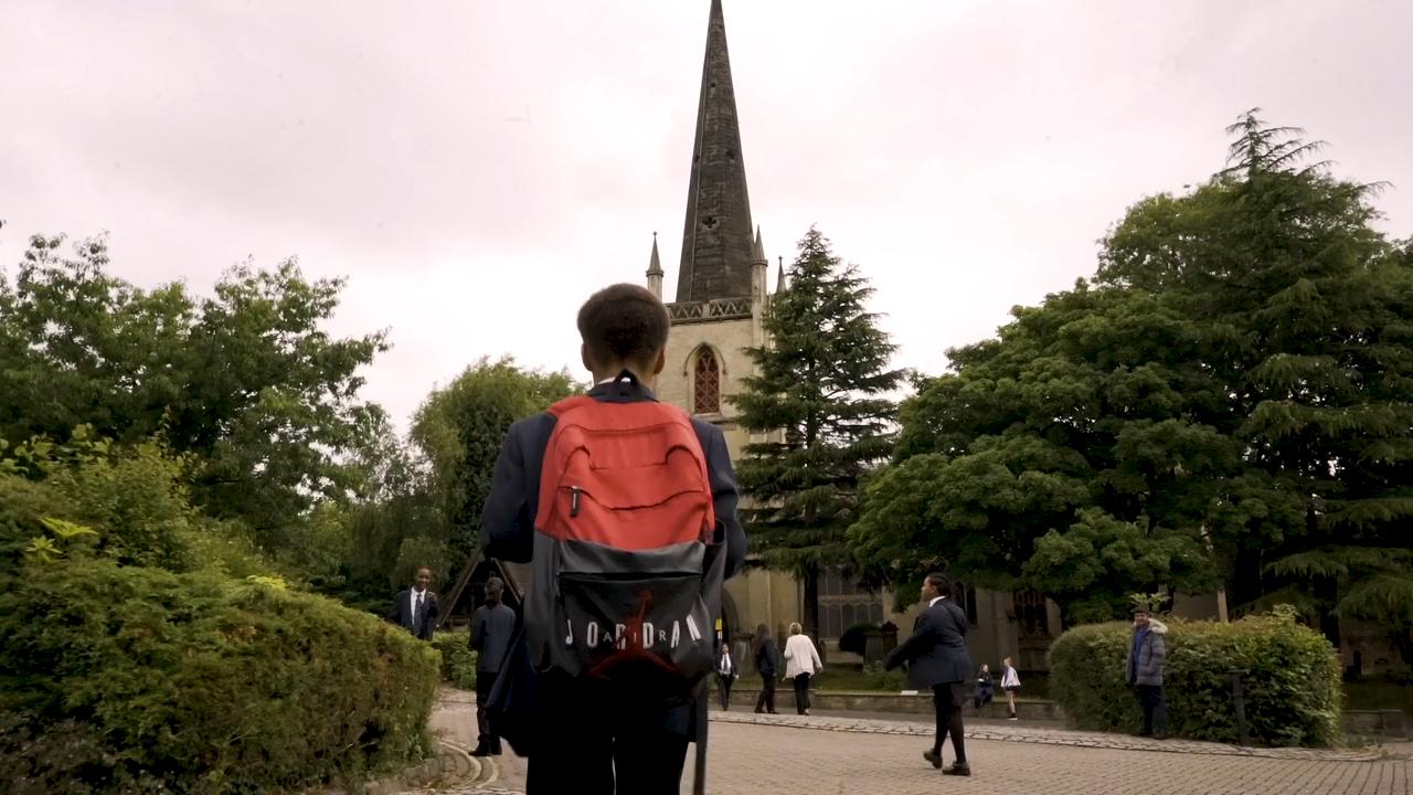 Pupils head over to St Matthew's church. Along the path are green bushes and trees.